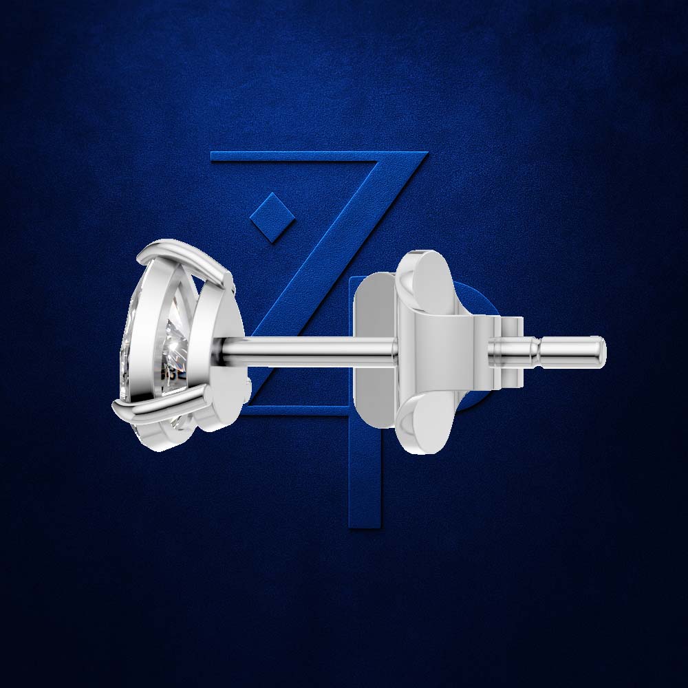 A pair of silver-toned stud earrings with round clear gemstones, shown from the side against a textured dark blue background with a large stylized 'Z' logo.