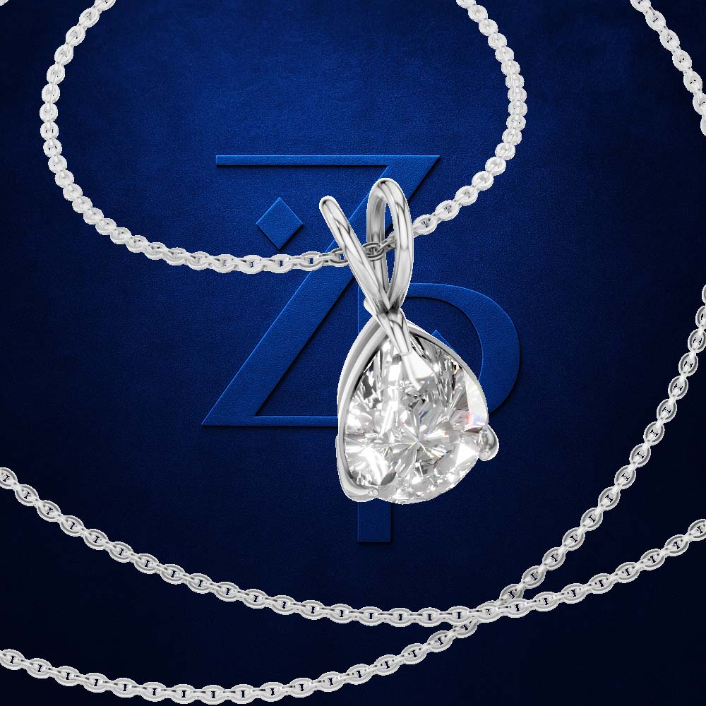 A silver-tone pendant necklace with a pear-cut clear gemstone in a prong setting, shown on a dark blue textured background with a large stylized 'Z' logo behind it.