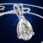 A teardrop-shaped diamond pendant in a silver-colored setting on a matching chain, set against a dark blue background with a subtle blue 'D' emblem.