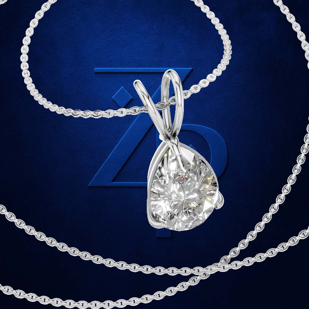 A silver-toned pendant necklace with a large, round brilliant-cut clear gemstone, displayed on a textured dark blue background with a large blue 'Z' logo behind it.