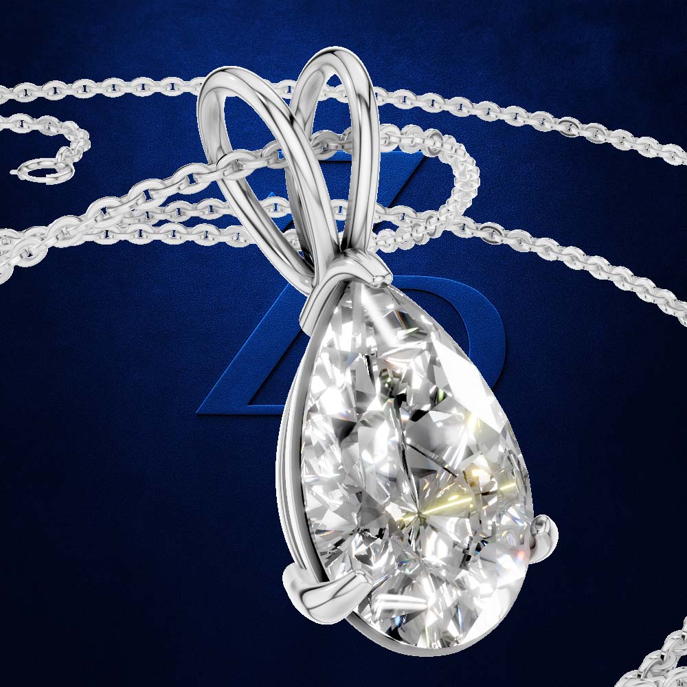 A teardrop-shaped diamond pendant in a silver-colored setting on a matching chain, set against a dark blue background with a subtle logo.