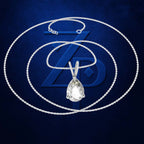 A silver-tone chain necklace with a teardrop-shaped clear gemstone pendant, displayed against a dark blue textured background with a large stylized 'ZD' logo behind it.