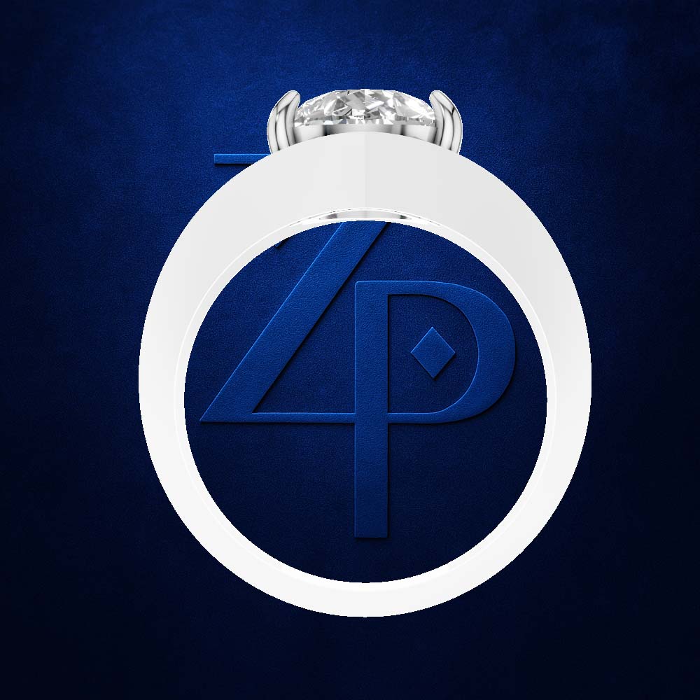 A silver ring with a round brilliant-cut diamond set in a circular bezel, centered on a textured dark blue background. The ring features a large, circular white inlay with a raised blue monogram logo inside.