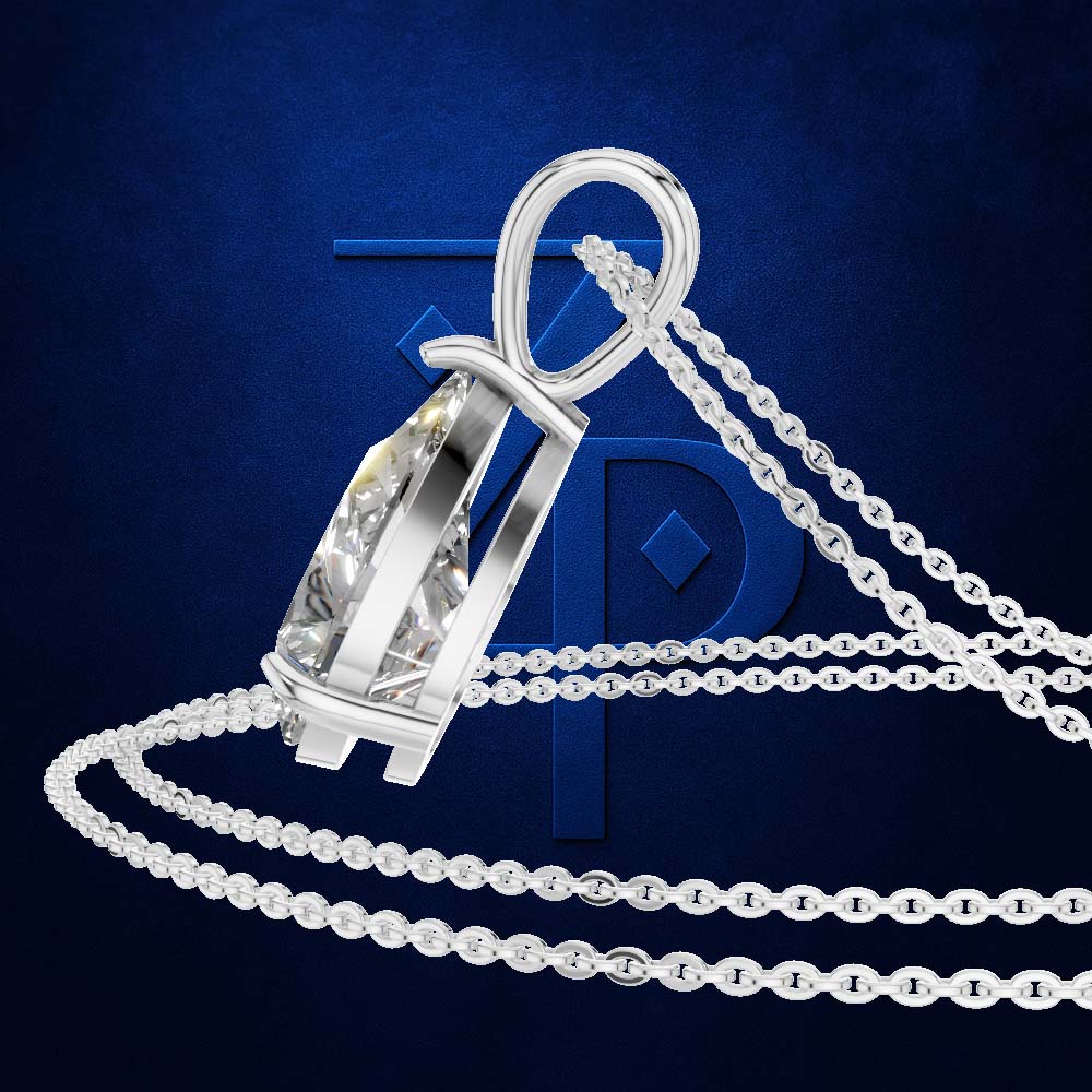 A silver-toned pendant necklace with a clear faceted gemstone in a polished bezel setting, shown with a matching chain on a dark blue textured background with a large blue monogram behind it.