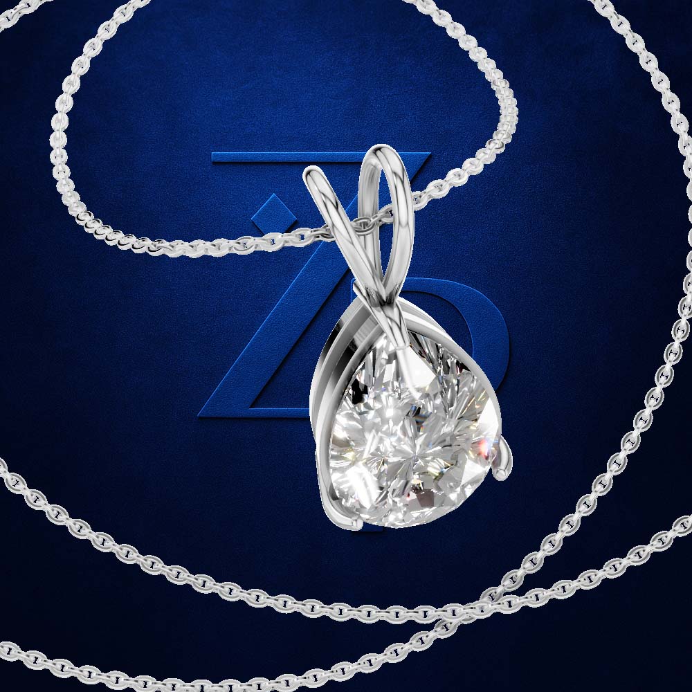 A silver-toned pendant necklace with a teardrop-shaped clear gemstone, shown on a dark blue background with a large stylized Z logo behind it.