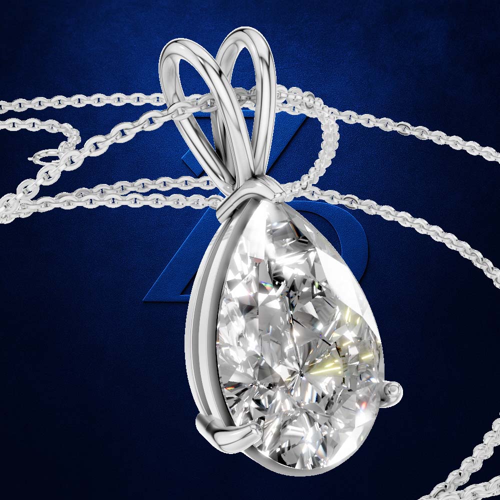 A teardrop-shaped diamond pendant in a silver-colored setting on a matching chain, set against a dark blue background with a subtle geometric design.