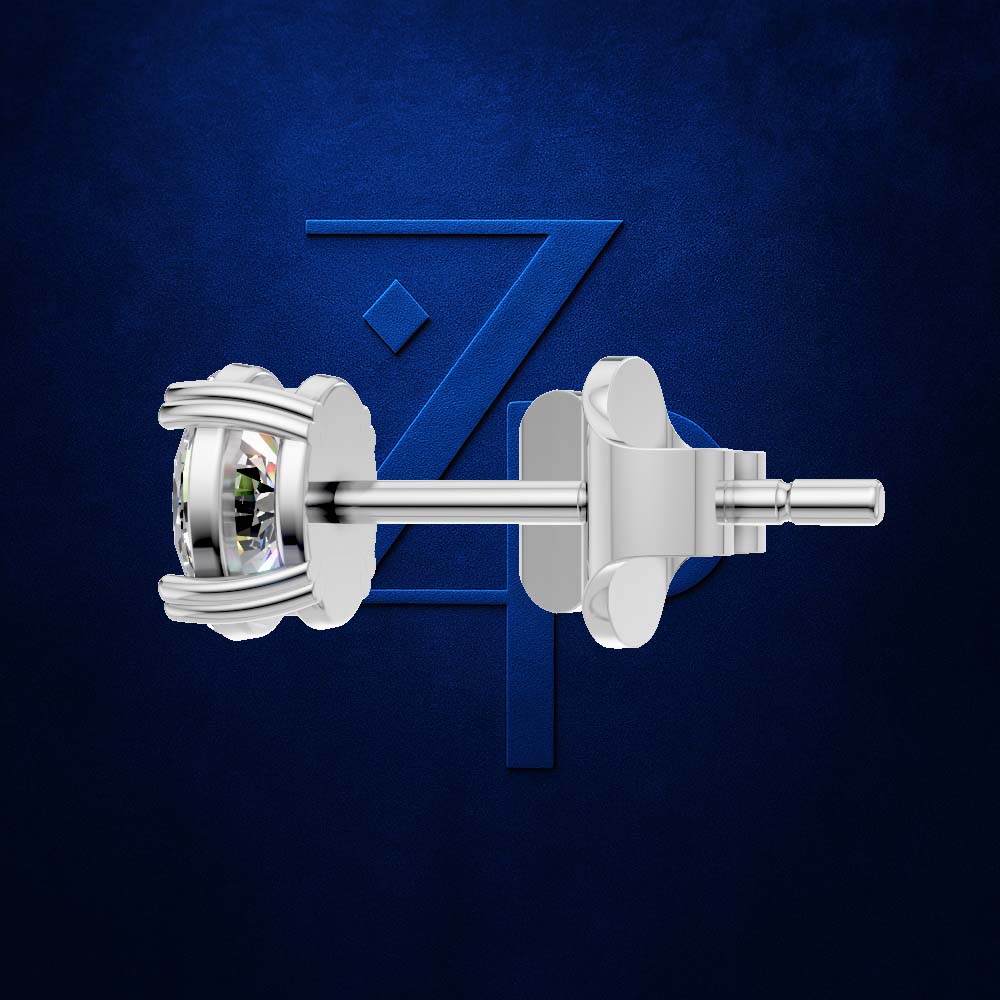 A pair of silver-toned stud earrings with bezel-set clear gemstones, shown from the side against a textured dark blue background with a subtle stylized 'Z' logo.