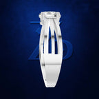 A white gold or platinum ring with a rectangular cushion-cut diamond, shown from a front-three-quarters angle against a dark textured blue background with a subtle blue geometric logo.