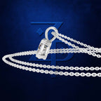 A silver-toned chain necklace with a cylindrical pendant, displayed on a textured dark blue background with a large stylized blue ZP logo behind it.