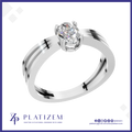 A silver-tone solitaire engagement ring with a round-cut clear gemstone, displayed on a white background with a blue border. The brand name 'PLATIZEM' is visible at the bottom.