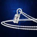 A silver-toned pendant necklace featuring a faceted geometric cage design, displayed on a dark textured blue background with a large stylized logo behind it.