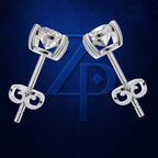 A pair of silver-toned stud earrings with round clear gemstones in prong settings, arranged symmetrically on a dark blue textured background with a large blue monogram behind them.