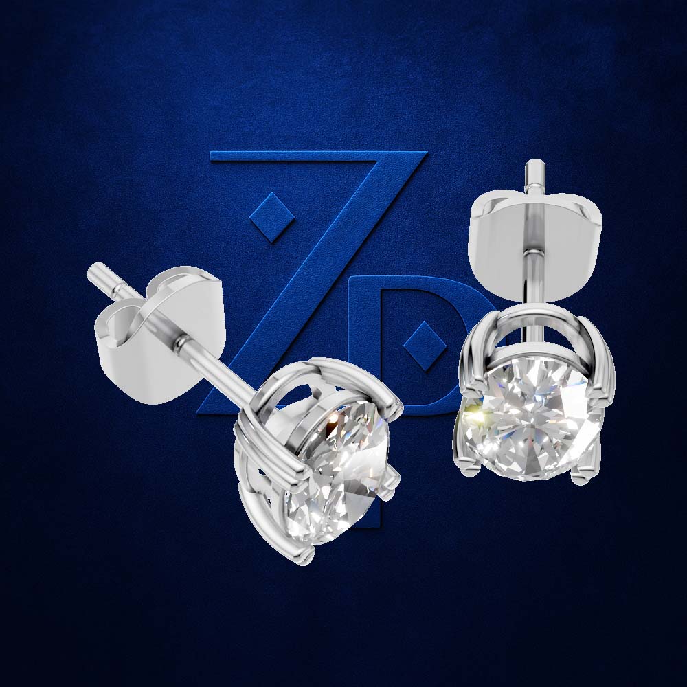 A pair of silver stud earrings with round clear gemstones, shown from both front and side angles against a dark blue textured background with a subtle stylized 'ZP' logo.