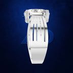 A white multi-strand ring band with a clear gemstone in a silver-toned setting, shown against a dark textured blue background.