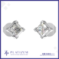 A pair of diamond stud earrings shown on a white background with a blue border. The earrings feature princess-cut diamonds in a four-prong silver setting.