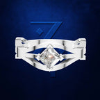 A silver-toned ring with a large clear diamond set against a textured dark blue background with a stylized blue '7' behind it.