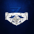 A silver-toned ring featuring a large, brilliant-cut clear gemstone in a geometric prong setting, presented against a textured dark blue background with a subtle blue graphic.