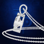 A silver-toned pendant necklace featuring a large, openwork geometric letter H pendant with a clear faceted center stone, suspended from a thick silver curb chain against a textured dark blue background.