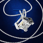 A silver-toned necklace with a geometric open-frame pendant holding a large clear faceted gemstone, shown on a dark blue background with a stylized blue 'Z' logo.