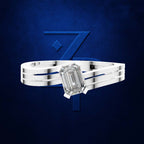 A silver-toned ring with a large rectangular emerald-cut clear gemstone, shown against a dark blue textured background with a large blue stylized 'Z' logo behind it.
