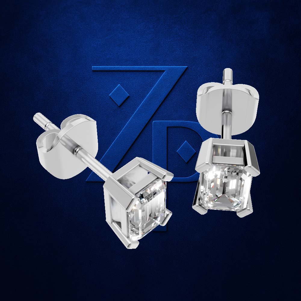 A pair of silver stud earrings with clear faceted cubic zirconia stones, shown from both front and side angles against a textured dark blue background with a subtle brand logo.