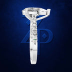 A white gold or platinum solitaire engagement ring featuring a large round brilliant-cut center stone and a channel-set row of smaller round stones on the shank, shown against a dark blue textured background with a stylized blue 'ZP' logo.