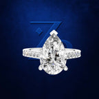 A pear-cut diamond ring with a pavé band, set against a dark blue textured background with a stylized blue 'Z' logo.
