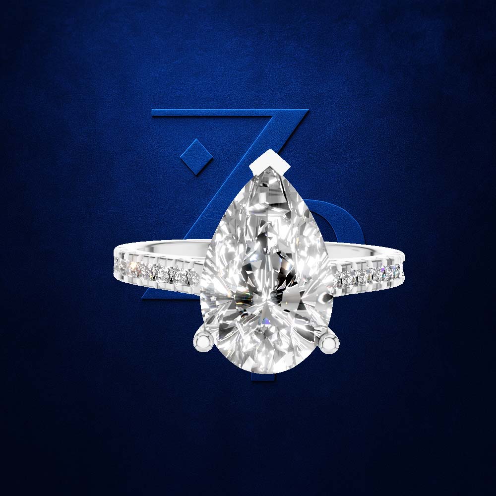 A pear-cut diamond ring with a pavé band, set against a dark blue textured background with a stylized blue 'Z' logo.