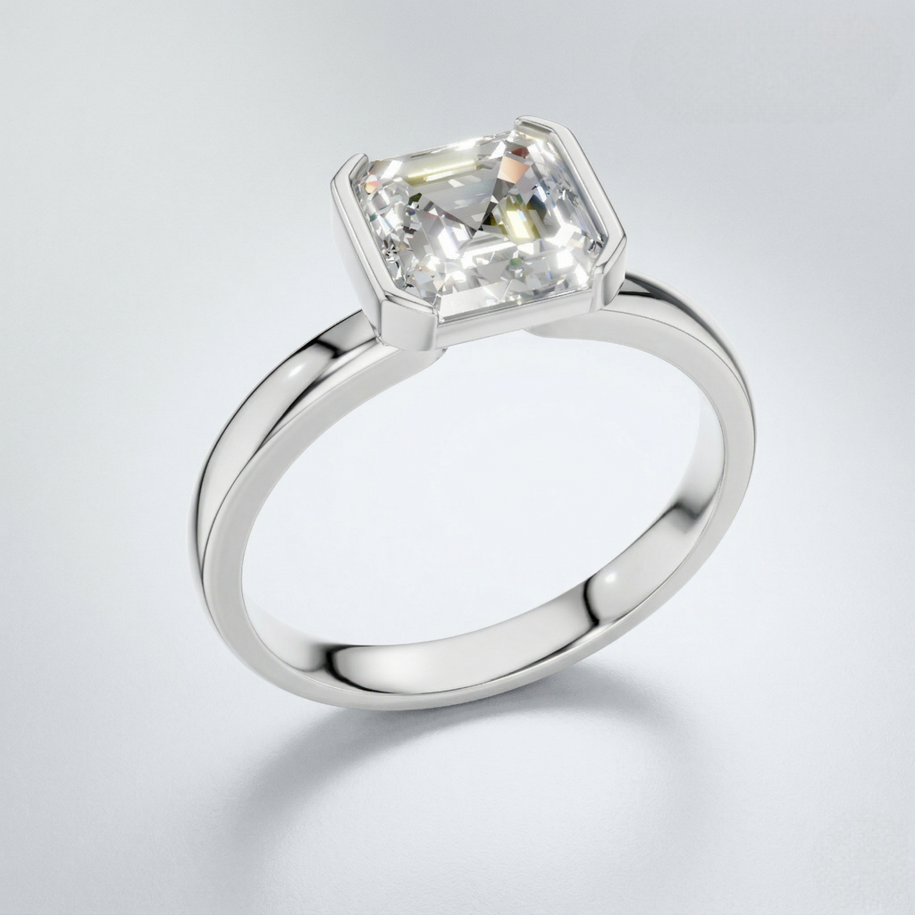 An emerald-cut diamond engagement ring in a polished white gold or platinum band, shown on a clean light gray background.