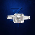 A silver ring with a large square emerald-cut clear gemstone, centered against a textured dark blue background with a stylized blue 'Z' logo.