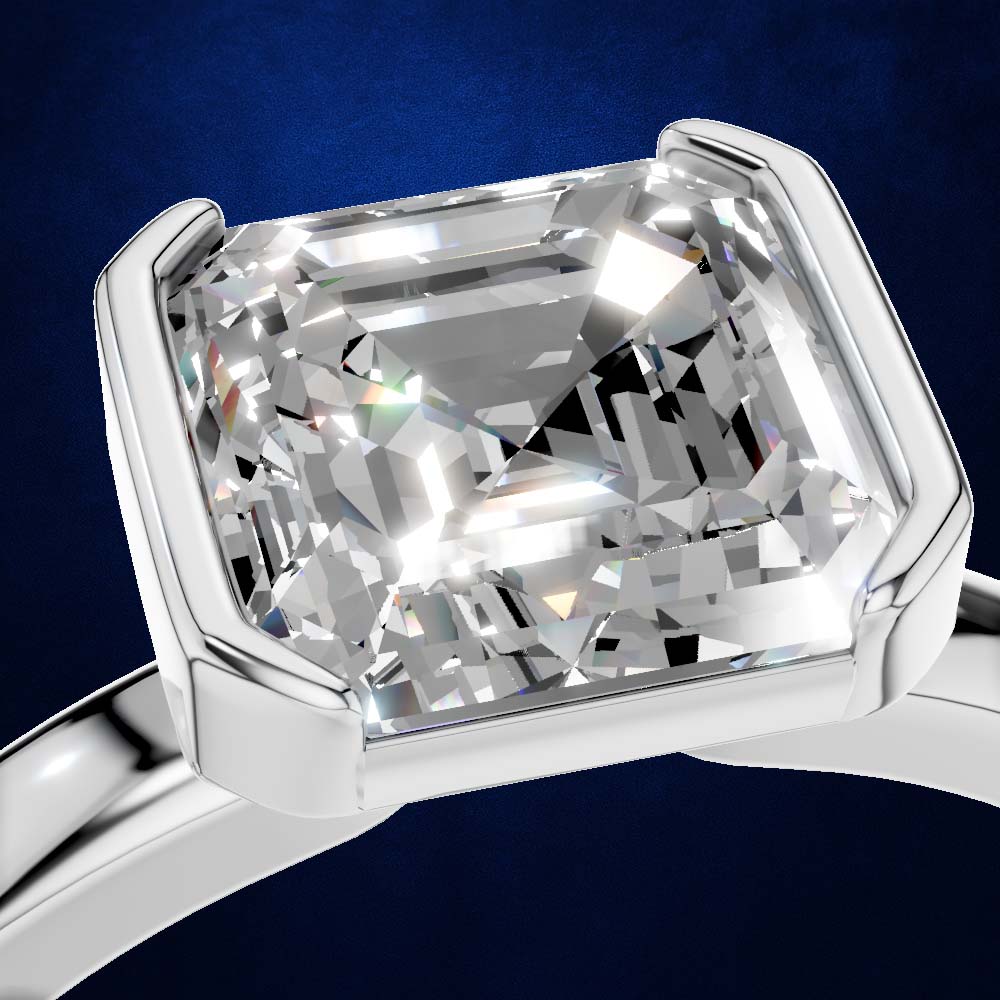 A close-up of a silver ring with a large cushion-cut clear gemstone in a prong setting, shown against a dark blue background.