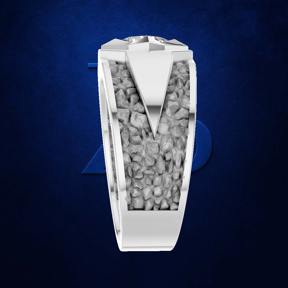 A silver-toned men's ring featuring a textured, pebble-filled channel with a polished V-shaped center and a round brilliant-cut gemstone on top, set against a dark blue textured background.