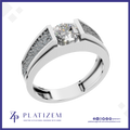 A platinum engagement ring featuring a round brilliant-cut center stone and pavé-set side stones, presented on a white background with the Platizem brand logo at the bottom.