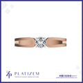 A rose gold solitaire ring with a round brilliant-cut diamond, presented on a white background with a blue border and the Platizem brand logo at the bottom.