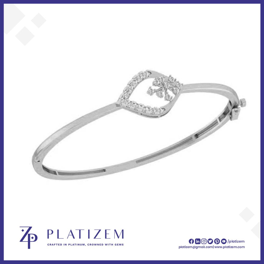 A silver-toned hinged bangle bracelet with a decorative heart-shaped frame set with small clear stones and a central floral motif, shown on a white background with the brand name PLATIZEM at the bottom.