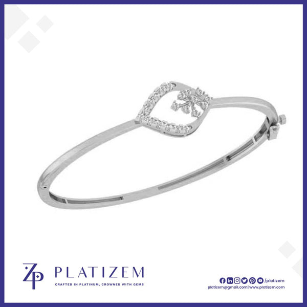 A silver-toned hinged bangle bracelet with a decorative heart-shaped frame set with small clear stones and a central floral motif, shown on a white background with the brand name PLATIZEM at the bottom.